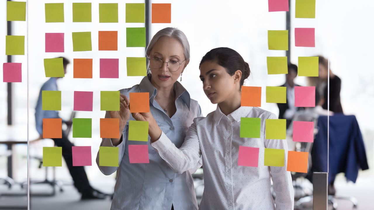 Two female project managers working on Advanced Professional Project Management assessments together