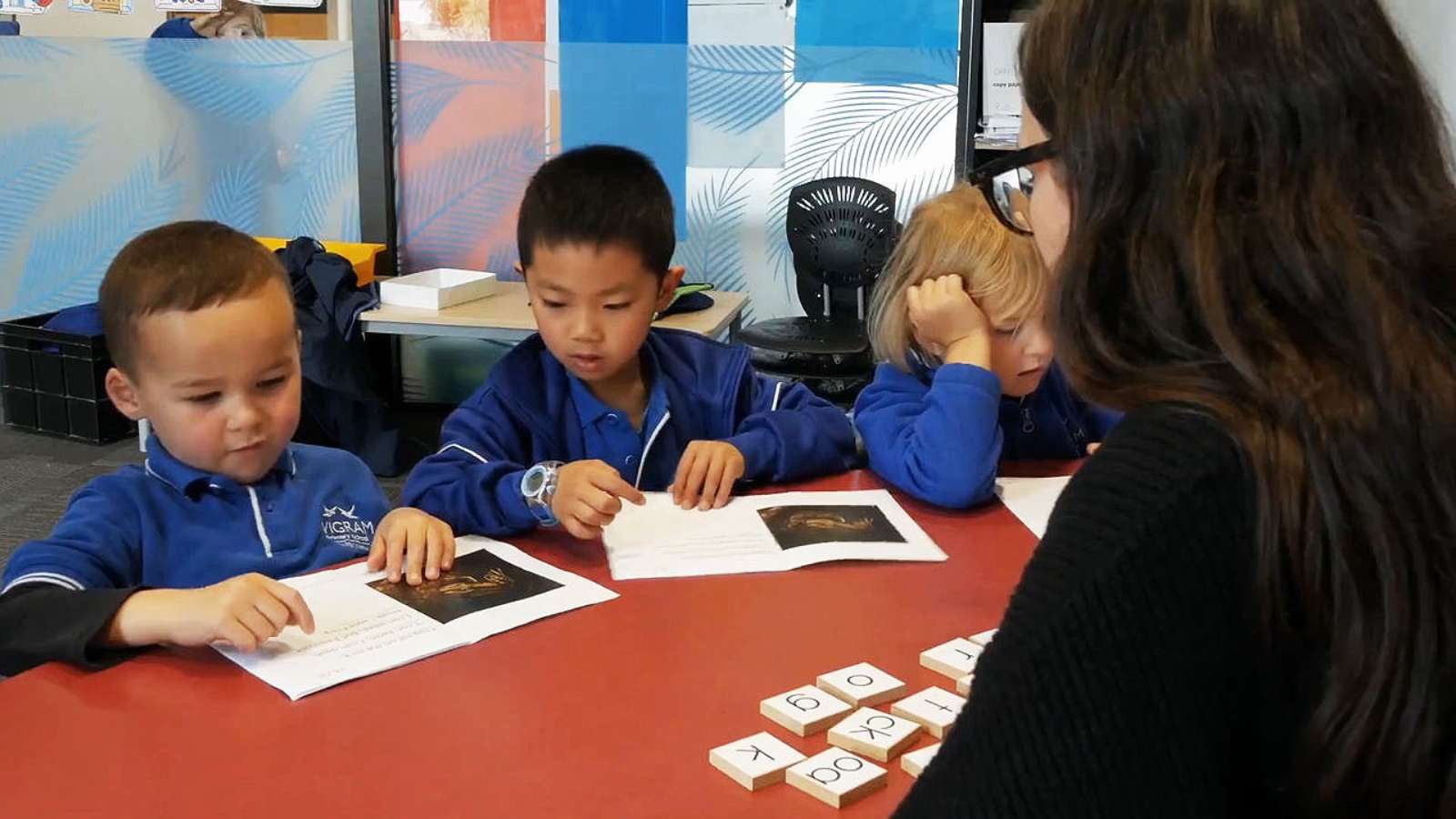 Children in a classroom completing literacy exercises after their teacher has done PLD training.