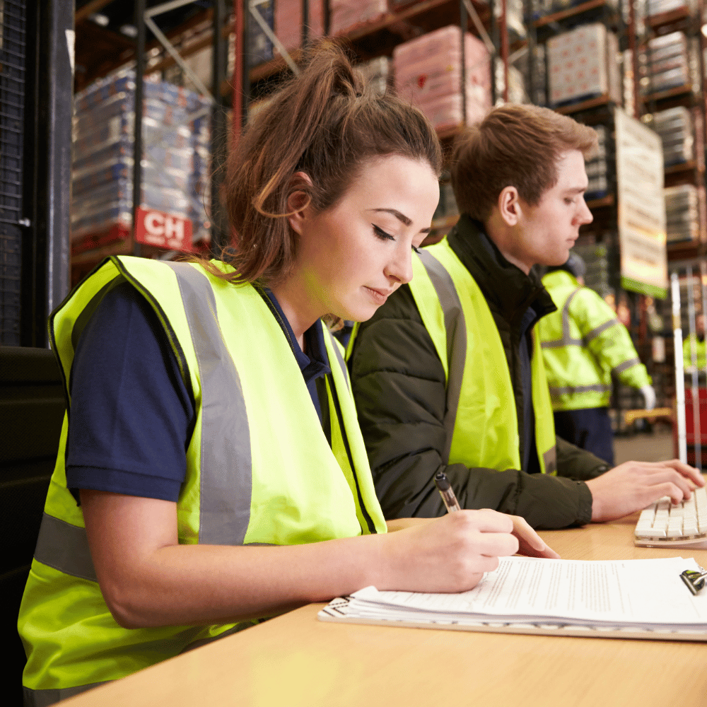 Two UC Online students, wearing high-visibility safety vests, study Law & Disaster Risk Reduction.