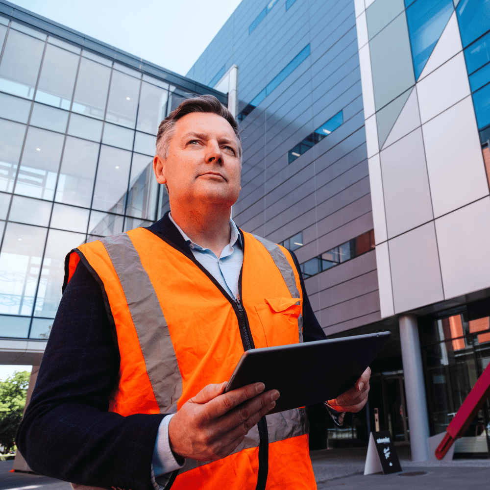 Man in hi-vis evaluating disaster risk after studying disaster law online. 