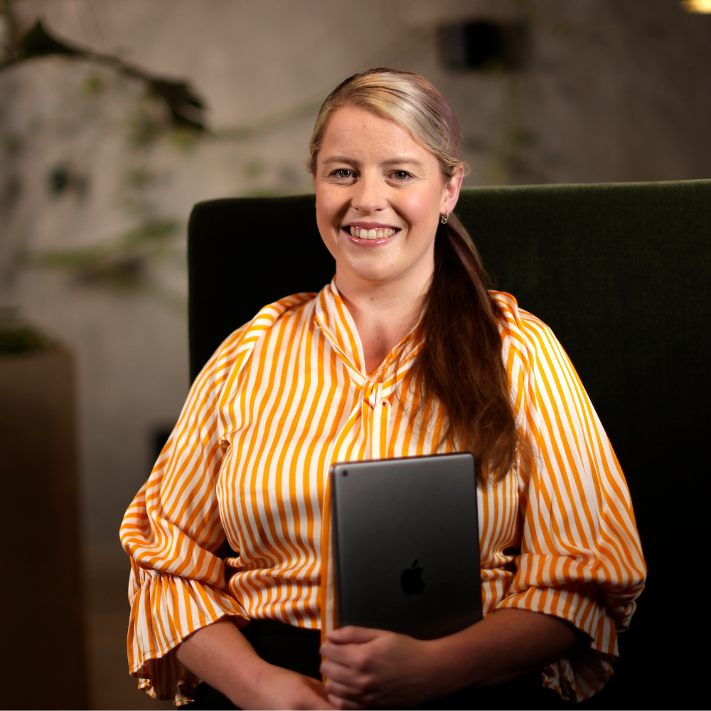 Adult learner in the justice sector smiling at camera after completing an assignment from her criminal justice course