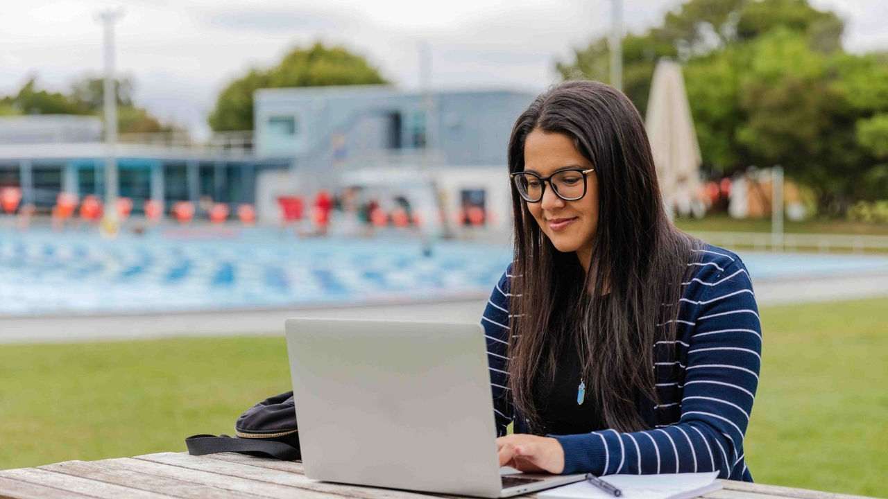 Female sports professional studying on a laptop for her online Master of Business Administration specialisation in sport.