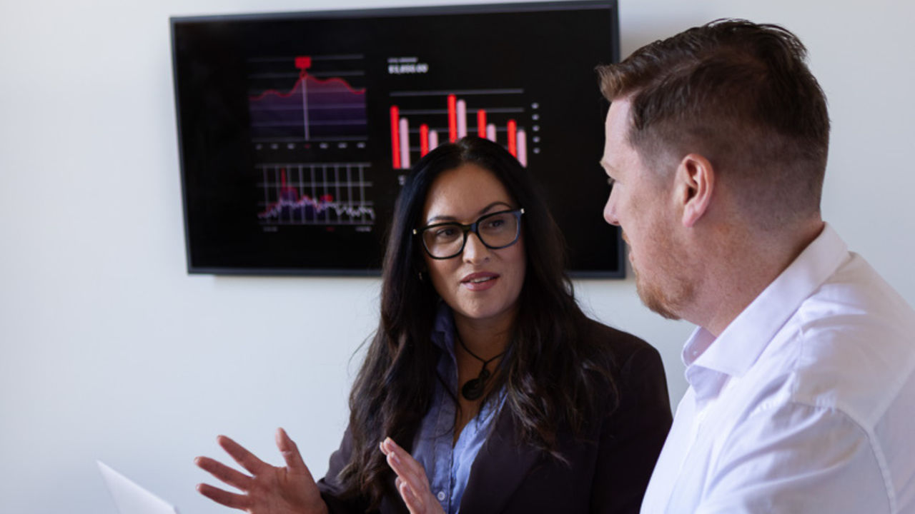 Two professionals discussing a project, representing learners in an online Master of Business Administration specialisation in technology