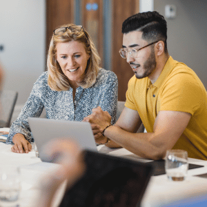 UC Online students discuss research methodology while working off a shared laptop.