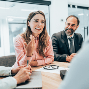 A confident woman uses skills learned in the UC Online Master of Organisational Psychology to lead a boardroom discussion. 