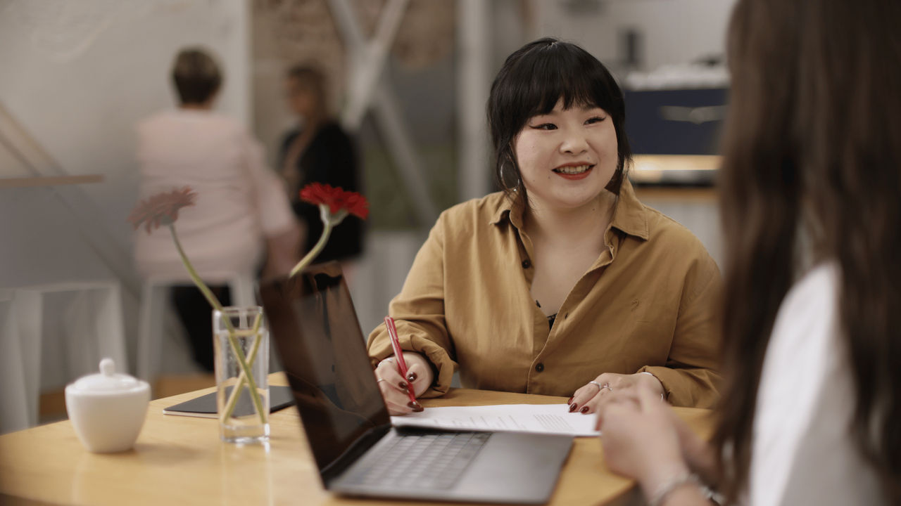 A UC Online Digital Marketing student takes notes while listening to an industry expert.