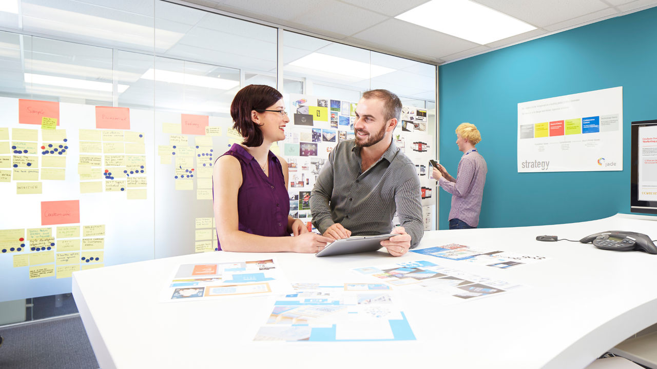 Two people working at a desk, smiling