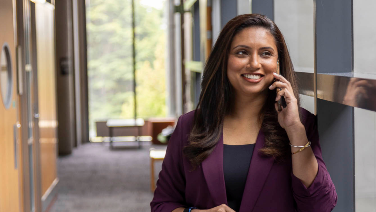 Woman smiling as she discusses her online MBA with specialisation options in Health, Technology and Sport.