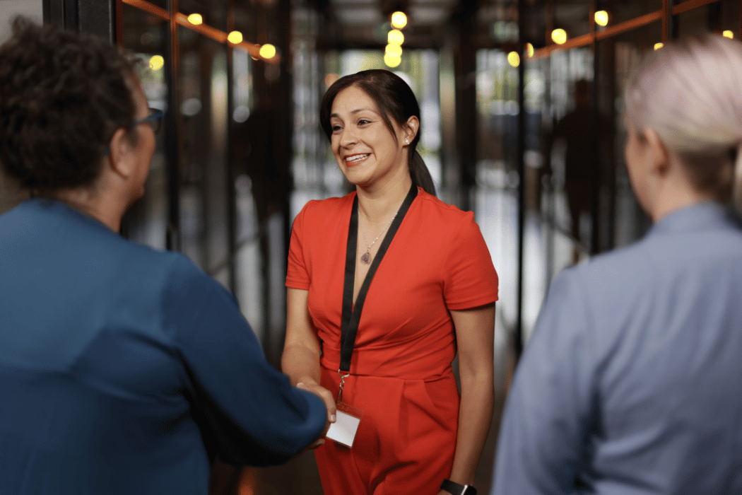 A smiling HR manager greets members of the UC Online Partnerships team as they visit her workplace.