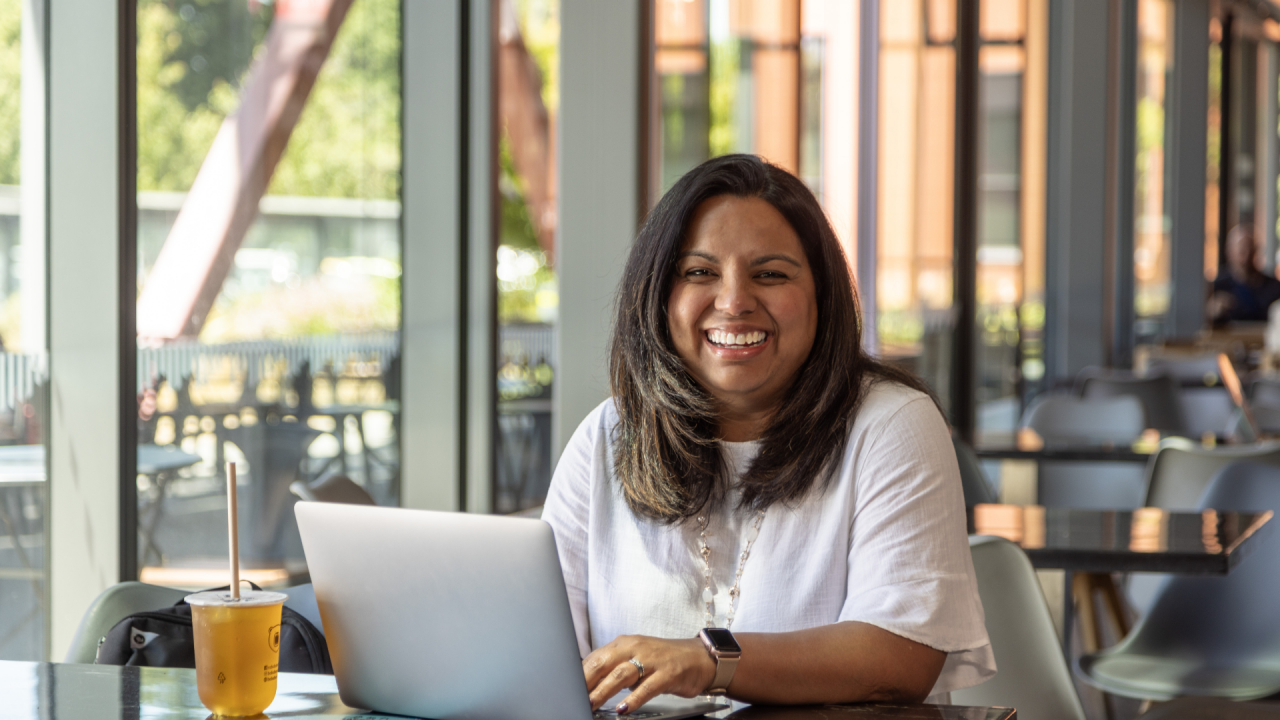 Learn to Get Better at Generative AI with Tuihono UC like this professional woman sitting in working space with her laptop.