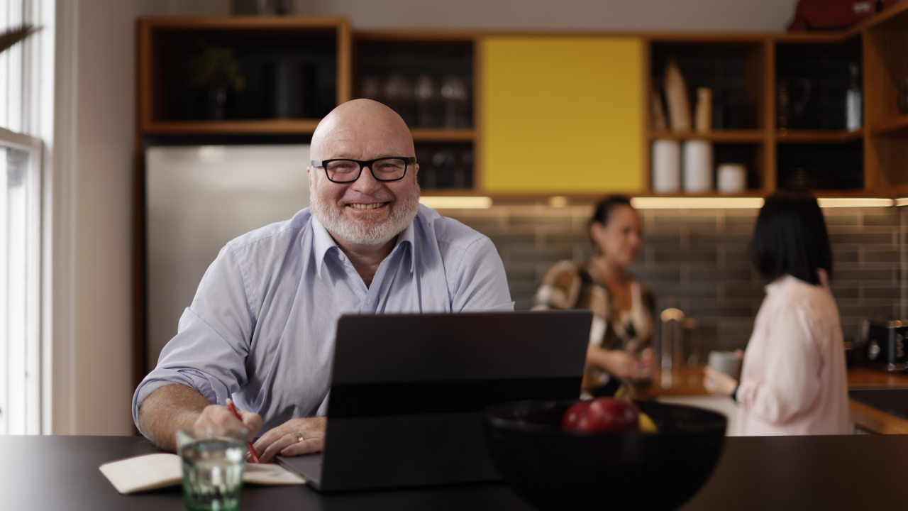 Upskill in Risk Management Essentials with UC Online like this man in front of a laptop in an office environment.