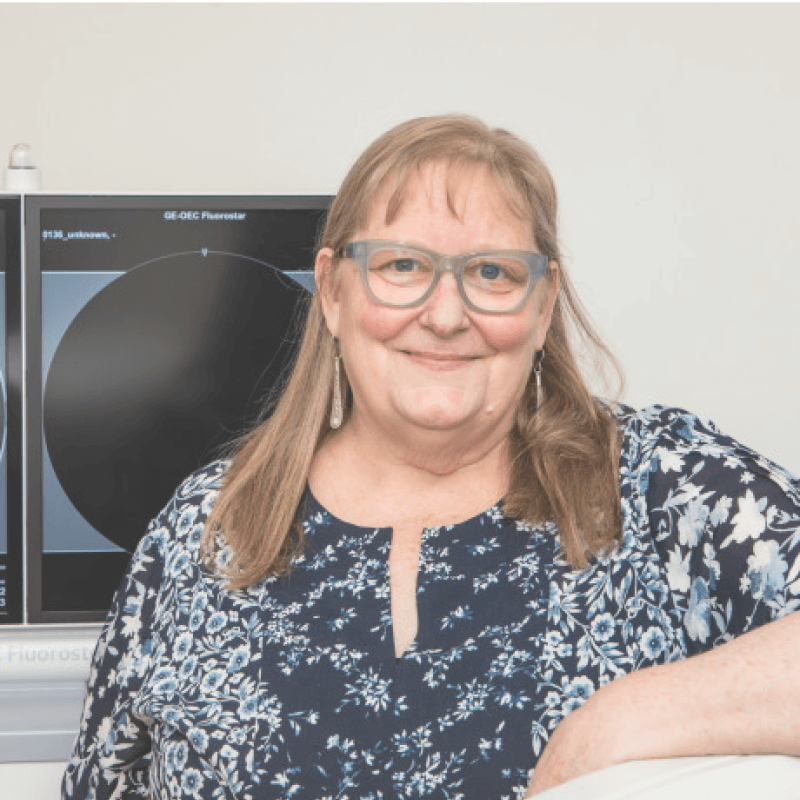 Professor Maggie-Lee Huckabee, with X-ray viewing screen behind her